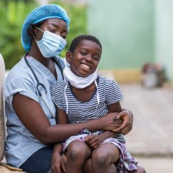 A closeup shot of a boy and a doctor wearing sanitary masks